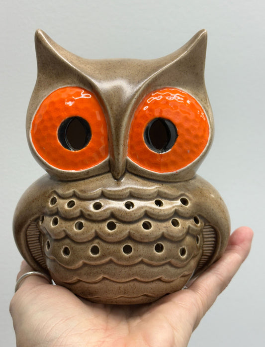 Ceramic owl-shaped incense burner held in a hand against a gray background